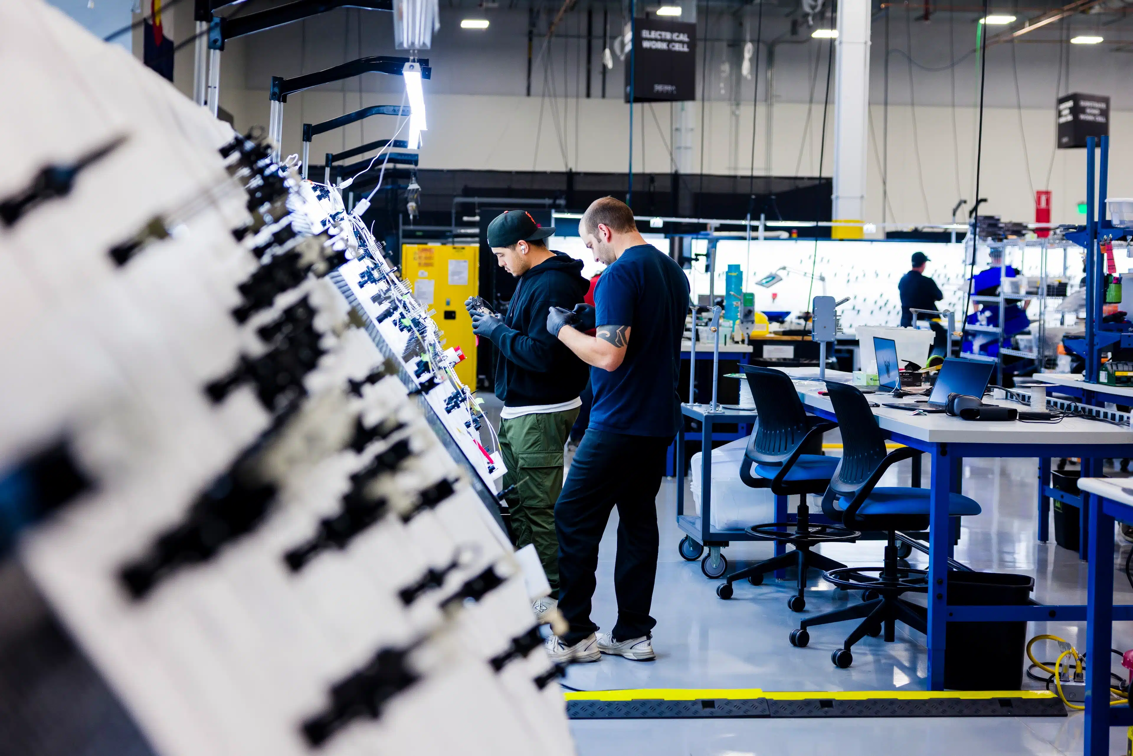 Two Sierra Space team members working together at an electronics workcell