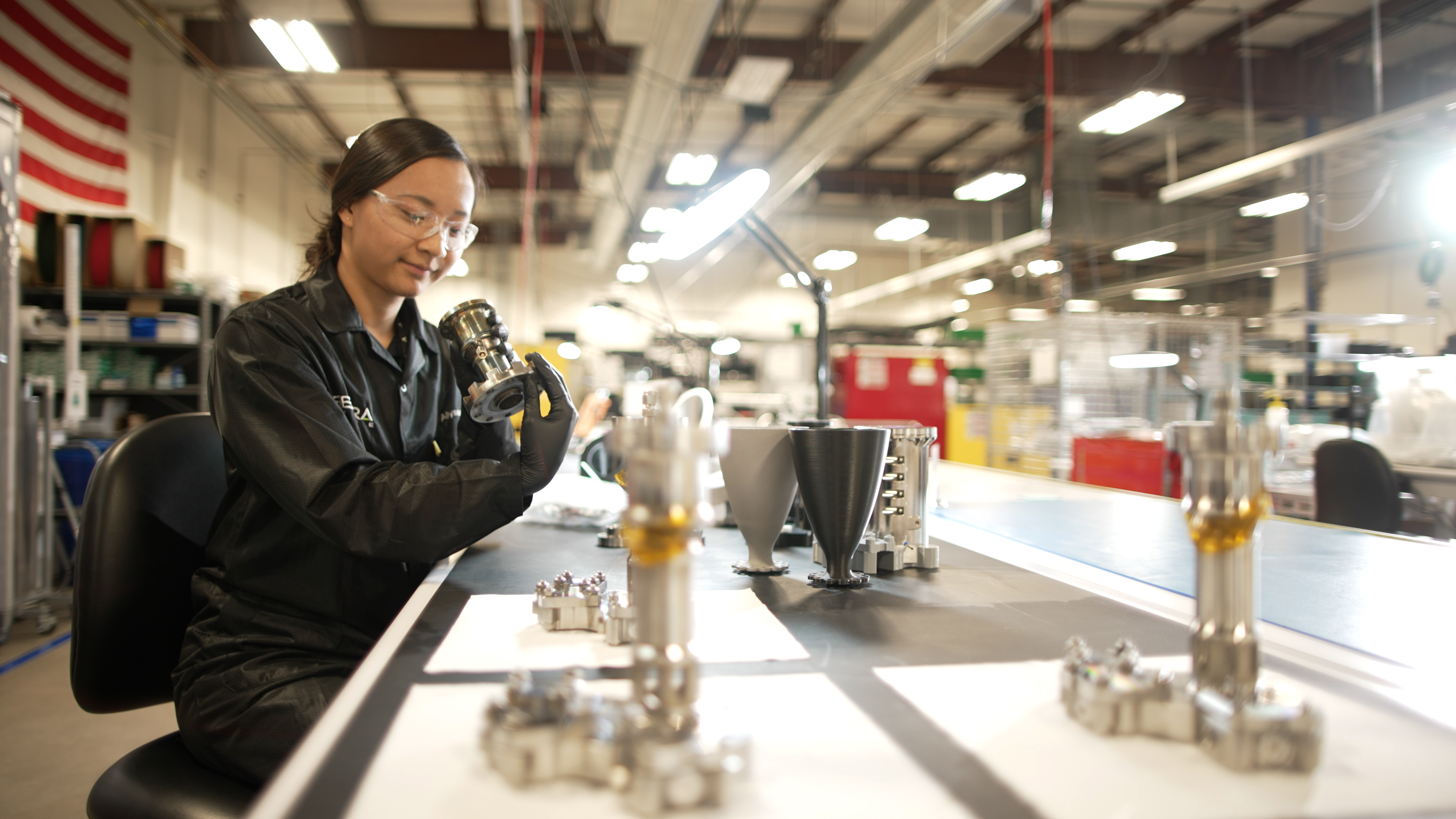 Worker inspecting hardware at a workbench