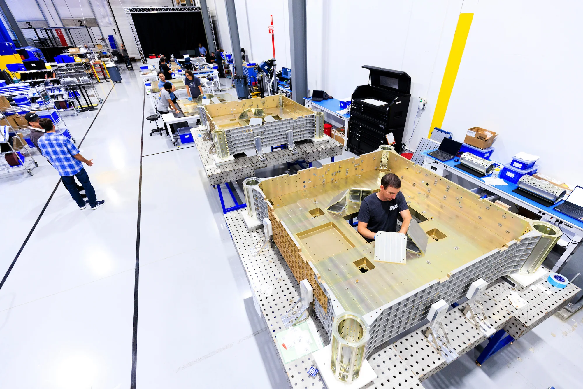 Technicians working within structural assemblies on the Victory Works production floor
